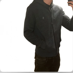 Ralph Lauren Hoodie - Tja säljer nu en riktigt snygg Ralph lauren hoodie i storlek M och i färgen grå i performance material. Hoodien är i ett fint skick utan några defekter som hål eller fläckar. Nypris 2395kr mitt pris 499kr. Hör av dig vid frågor eller funderingar! Pris ej hugget i sten!