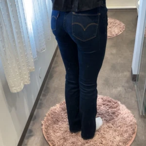 Levi's 715 Bootcut jeans mörkblå - Mörkblå Levi's 715 Bootcut jeans med klassiska kontrastsömmar och femficksdesign. Snygg bootcut-modell med normal passform och hög midja. Tillverkade i stretchig denim för en bekväm känsla och perfekt fit. 