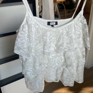 Vit spetslinne från Bik Bok XS - Supersött vitt linne från Bik Bok i storlek XS. Toppen har tunna axelband och är av vacker spets med blommigt mönster. Perfekt för sommarens varma dagar.