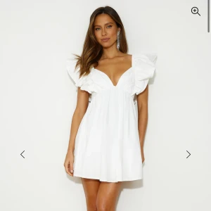 Vit kortklänning med volangärmar - Supersöt vit kortklänning med v-ringad hals och stora volangärmar. Bara använd en gång på studenten, den är lite uppsydd i v-ringningen men går såklart att sprätta upp💕 den har rosett i ryggen. Köpte för 1700