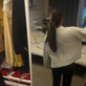 Ljusgrå stickad tröja med slits i ärm - Supermysig ljusgrå stickad tröja med breda, långa ärmar och slitsdetalj vid ärmslut. Tröjan har en loose passform och ribbad struktur som ger en chill vibe. Perfekt att slänga på sig när det är kallt ute.