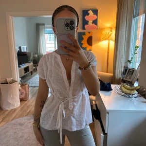 Vit blus med knyt och broderi - Denna toppen är så fin!! Gör typ lite ont att sälja men jag anvönder den på tok för lite! Den är min mamma gamla från bondelid i XS har klippt i den där nere men det syns knappt! Den kan knytas lite hur som helst med banden där fram ☺️