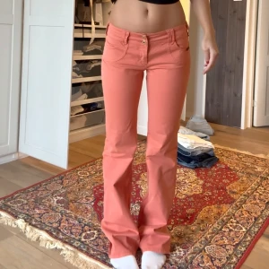 Korallrosa bootcut jeans Dolce&Gabbana - Säljer ett par skiitsnygga korallrosa jeans från Dolce&Gabbana med bootcut-modell och låg midja. Köpta vintage i Italien men är i väldigt fint skick!