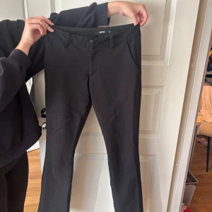 Svarta kostymbyxor från Bik Bok - Svarta kostymbyxor från Bik Bok med klassisk rak passform . Byxorna har diskreta fickor fram och bak, stängs med dragkedja och knapp. Perfekta till en snygg och clean look.