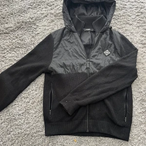 Cardigan från J.Lindeberg - Svart jacka/cardigan från J.Lundeberg perfekt nu när de börjar bli lite kallare. Jackan är i bra skick inga defekter men lite nopprig. Ny pris på jackan 4000! Hör av er för frågor!🤩🤩🤩