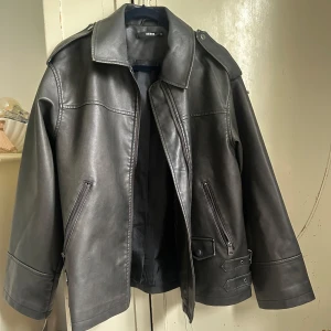 Skinnjacka bikbok - Så snygg skinnjacka i PU (polyertan och polyester) från bikbok i storlek xs😇 Nypris 999kr  Super bra skick! Vintage look och skiftar i svart, lite grå och lite brun!
