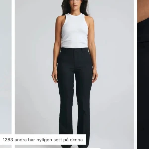 Svarta kostymbyxor med bootcut - Snygga svarta kostymbyxor med bootcut-snitt och hög midja. Byxorna har klassisk rak passform, diskret dragkedja och knapp framtill. Perfekta för en clean och stilren look, passar till både sneakers och klackar.