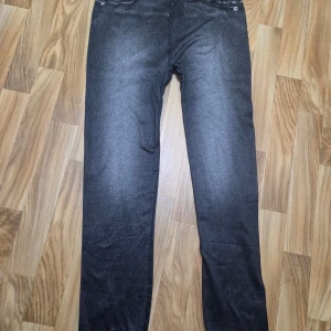 Svarta leggings med jeansmönster - Säljer ett par svarta leggings med tryckt jeansmönster. De har klassiska jeansdetaljer som tryckta fickor och sömmar, men är gjorda i ett stretchigt och mjukt material. Perfekta om du vill ha jeanslooken men ändå känna dig bekväm hela dagen.