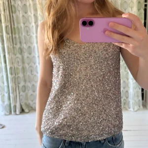 Glittrigt paljettlinne från Mango - Supersnyggt glittrigt linne från Mango i bra skick! Roséfärgat men paljetterna gör att det ser silvrigt ut i vissa ljus. Perfekt för fest, konsert eller varför inte nyår!!💖