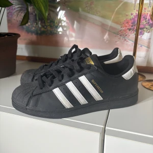 Adidas Superstar svart/vit strl 38⅔ - Säljer nu mina svarta Adidas Superstar, har använt dom 5 gånger så de är i bra skick. Som nya! ☺️ skriv för fler bilder 🫶🏽