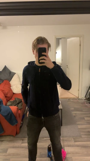 Mörkblå hoodie i kashmir från Sayless - Snygg mörkblå hoodie från Sayless i mjuk kashmir. Tröjan har huva med snörning, dragkedja framtill och två fickor. Perfekt för dig som gillar stilrena och bekväma plagg med lite lyxig känsla. Passar dig som vill ha en hoodie med premiumkänsla.