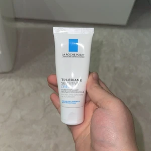 La Roche-Posay Toleriane Sensitive Creme - Toleriane Sensitive Creme från La Roche-Posay är en återfuktande ansiktskräm i en vit tub med blå detaljer. Innehåller 40 ml och är perfekt för känslig hud. Formulan är lätt och absorberas snabbt, med lugnande och skyddande egenskaper tack vare termalvatten.