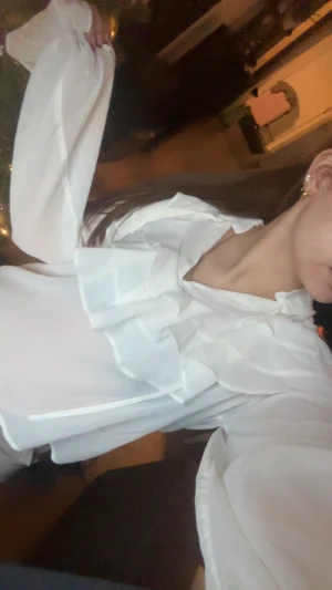 Vit blus med volanger och lång ärm - Säljer en vit blus med transparent tyg och snygga volanger framtill. Blusen har långa ärmar med resår och volangdetaljer vid ärmslut. Luftig passform och romantisk look, perfekt för dig som gillar trendiga detaljer. Använd endast en gång.