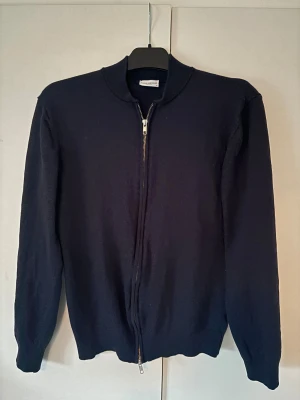 John Henric  - En sjukt snygg eftertraktad blå John Henric kofta i storlek L (sitter som m) och av 100% merinoull. Grymt skick inga defekter så ett riktigt kap! Nypris på ca 1500 och sitter grymt!
