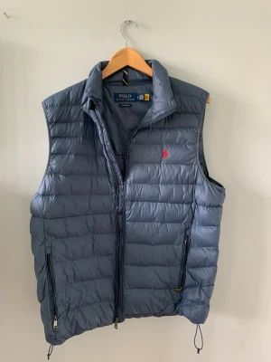 Blå väst från Ralph Lauren - Säljer min riktigt fina RL väst då jag inte använder den längre, storlek M men sitter stort i storleken. Bra skick en defekt (fläck). Kom privat för att se den men den är ej så tydlig. Hör av er vid frågor eller funderingar!!!