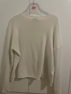 Vit stickad tröja från Zara - En enkel och stilren vit stickad tröja från Zara i storlek S. Tröjan har lång ärm, rund hals och en loose passform som ger en chill vibe. Perfekt att slänga på sig när det är lite kyligt ute. Materialet är mjukt och skönt mot huden.