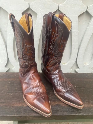 Bruna cowboy boots - Ett par bruna cowboy boots i mycket fint skick från märket ”Buffalo”. Klassiska och stilrena, perfekt för att höja stilen på din outfit. Storlek 43