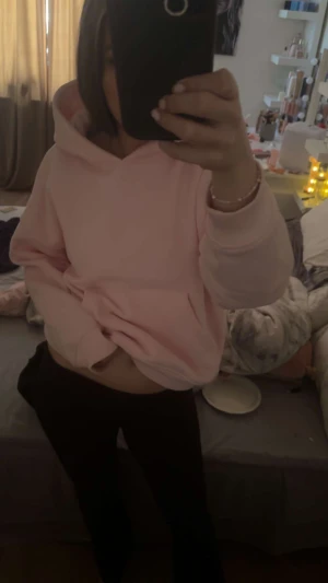 Ljusrosa hoodie med huva - Säljer en ljusrosa hoodie med stor huva och sköna muddar vid ärmslut och nederkant. Tröjan har en loose passform och är perfekt för chill dagar. Mjuk och bekväm, passar dig som gillar enkel och stilren look.