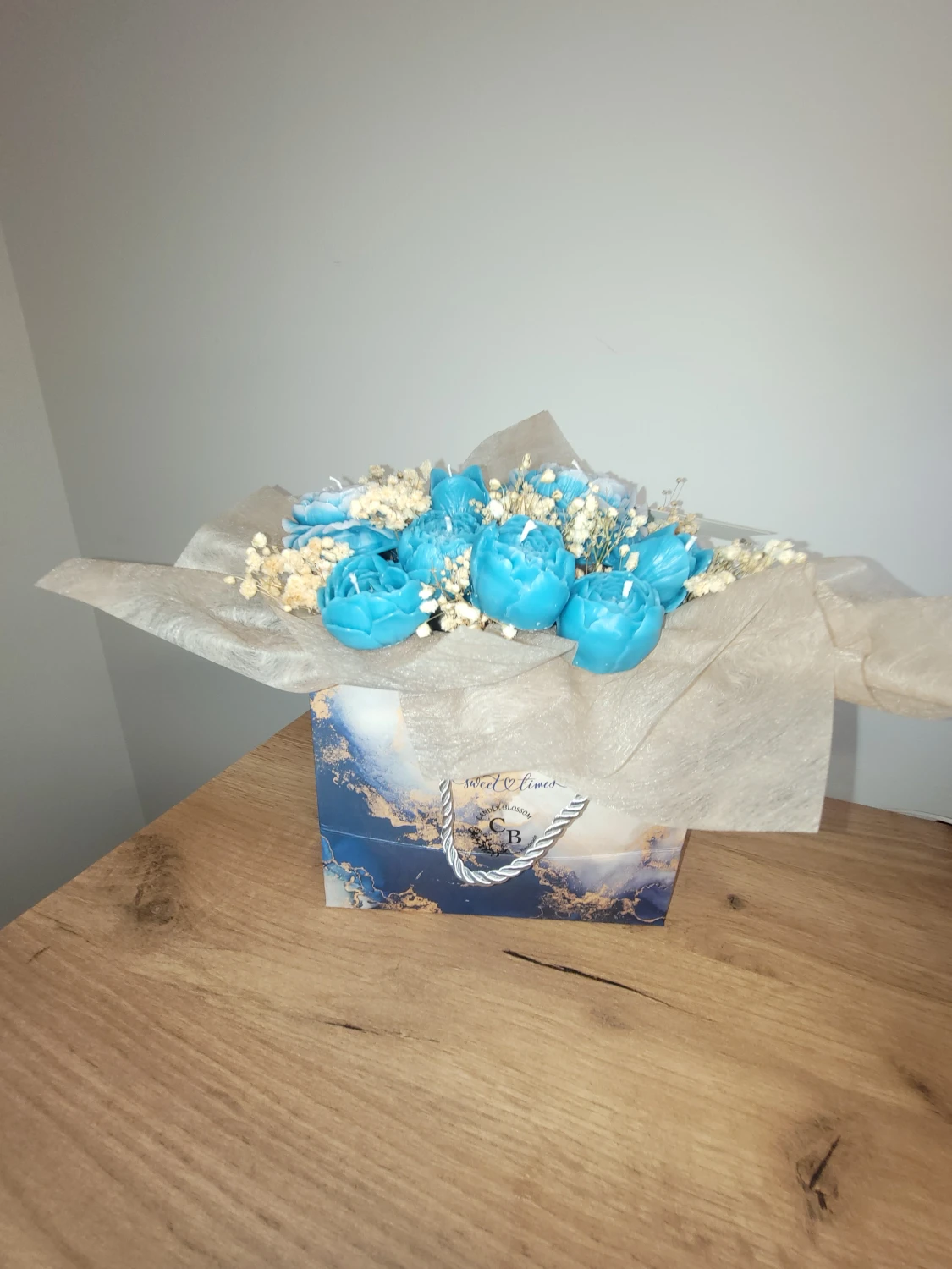 Blå blomformade ljus i presentpåse