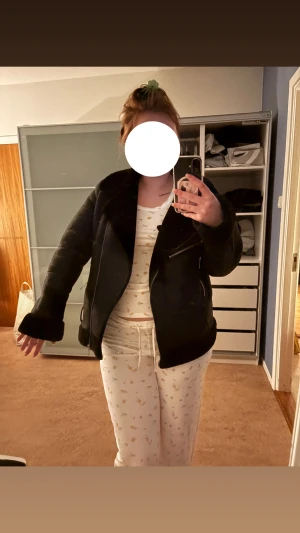 Svart pälsjacka med dragkedjor - Säljer en svart pälsjacka med bred krage och snygga silvriga dragkedjor. Jackan har lång ärm och mjukt fuskpälsfoder som syns vid muddar och krage. Perfekt för dig som vill ha en cool och varm look i vinter.