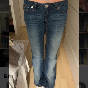 Blå bootcut jeans  - Snygga blå bootcut jeans med röda kontrastsömmar och broderade bakfickor. Klassisk femficksmodell med låg midja och lätt slitning framtill. Inga tecken på användning! 💕💕
