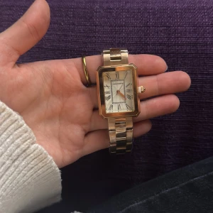 Loravento klocka  - Snygg klocka från Loravento i guldigt metallarmband och fyrkantig urtavla. Urtavlan är vit med romerska siffror och guldiga visare. Klassisk och stilren design som sticker ut med sin unika form. Fick klockan i present, men sedan gjorde vi slut. Priset kan förhandlas.
