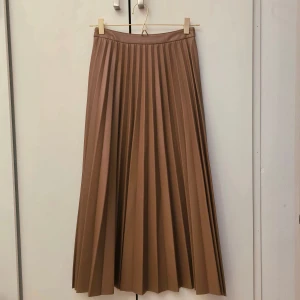 Mango Brun läderkjol i PU - 🌷FÖRST TILL KVARN!🌷Härlig plisserad brun läderkjol från Mango. Den är i stolek xs men skulle säga att den även passas s. Kjolen är i pu-läder och har även vegan mocka i insidan som är len och bekväm när man har på sig den. Kommer precis över anklarna. Vid intresse av köp kan jag mäta den. Skulle säga att det är en midi kjol. VILL BLI AV MED ASAP!🙏🏼