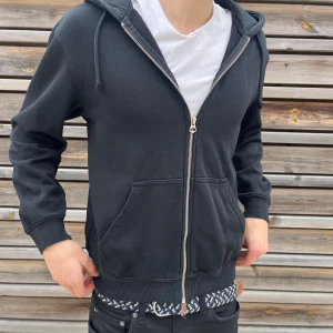 Weekday hoodie  - Svart hoodie från Weekday i storlek XS. Tröjan har dragkedja framtill, huva med snörning och två stora fickor. Tillverkad i mjuk bomullsmix och har en klassisk, avslappnad passform. Perfekt för chill dagar eller när du vill ha en enkel och stilren look.