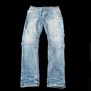 Blå grisch archive washed jeans - Jack jones blå jeans med snygga slitningar och distressed detaljer på både fram- och baksida. Klassisk femficksmodell med raka ben och normal passform. Jeansen har en cool tvättad look och är tillverkade i robust denim. Waist 44cm, full length 107cm