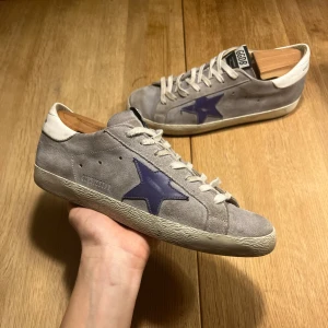 Golden Goose skor DB - Tja! Säljer dessa Golden Goose i modellen DB. Det är en sjukt snygg grå färg med en mörkblå stjärna. De är i mycket bra skick och kan vara sjukt snygga till vintern. Ingen box osv tillkommer, givetvis äkta. Hör av er för fler frågor!