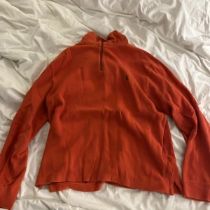 Vintage Orange half zip tröja från Polo Ralph Lauren - Säljer en vintage orange långärmad tröja från Polo Ralph Lauren med half zip och klassisk broderad logga på bröstet. Tröjan är i 100% bomull och har en hög krage. Perfekt för lager-på-lager och chill stil.