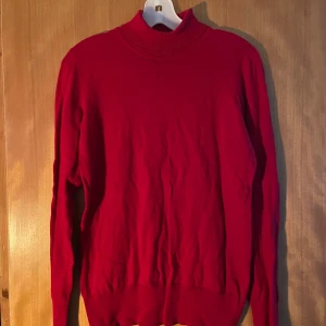 Röd polotröja med lång ärm - Snygg röd polotröja med lång ärm och ribbad krage. Perfekt för dig som vill ha en enkel men stilren tröja i garderoben. Passar bra till både jeans och kjol.