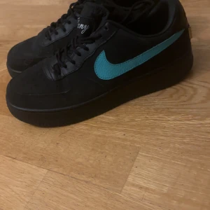 Nike Air Force 1 svart/turkos - Säljer ett par svarta Nike Air Force 1 med turkos swoosh och detaljer under sulan. Riktigt unika och säljer för extremt billigt . Använd max 3 gånger