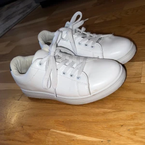 Vita sneakers från Cincinati - Fräscha vita sneakers från Cincinati med rund tå och platt sula. Skorna har snörning med vita skosnören och är tillverkade i syntetmaterial med mjuk textil på insidan. Klassisk och clean design som passar till det mesta. Perfekt för dig som gillar stilrena sneakers.