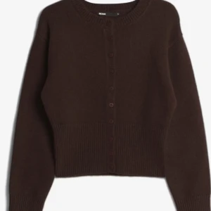 Mörkbrun kofta från Bik Bok - Mysig mörkbrun kofta från Bik Bok med rund halsringning och knappar hela vägen framtill. Tröjan är stickad i ett mjukt material och har ribbade muddar och midja för en snygg passform. Perfekt att slänga över en topp när det blir kyligt. Endast använd 1 gång så i nyskick. Sitter som en S-M men är storlek L. Nypris 499