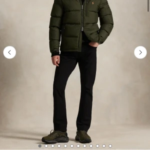 Mörkgrön pufferjacka från Polo Ralph Lauren - Snygg mörkgrön pufferjacka från Polo Ralph Lauren med orange logga på bröstet. Jackan har huva, flera dragkedjefickor och justerbara snören vid huvan. Perfekt för kalla dagar och har en schysst, lite oversized passform. ! EJ FAST PRIS SÅ KOM MED ERBJUDANDE!