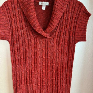 Unik rostfärgad tröja med sjalkrage Dressbarn - Rostfärgad stickad tröja från Dressbarn med korta ärmar och bred, ribbad sjalkrage. Snygg kabelstickad struktur framtill och ribbade detaljer vid ärmslut och nederkant. Perfekt för höstiga outfits. Supermjuk!
