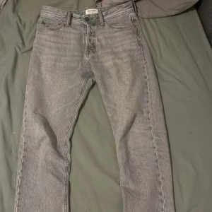 Grå relaxed chris jeans från Jack & Jones - Snygga grå jeans från Jack and Jones i modellen Chris fit. Ända nackdelen är den två hålen som finns på bakfickorna (se bild). Annars jätte bra skick o storlek W28 L30