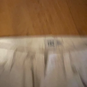 Beige jeansbyxor med raka ben - Snygga beige jeansbyxor med klassisk femficksdesign och raka ben. Byxorna har bälteshällor, knapp och dragkedja framtill samt detaljerade sömmar. Perfekt för dig som gillar en clean och stilren look.