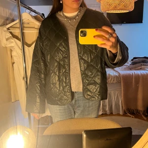 Quiltad mörkgrön jacka - Säljer en quiltad jacka i mörkgrönt med snyggt rutmönster. Jackan har tryckknappar framtill, lång ärm och loose passform. Perfekt nu i höst🗽