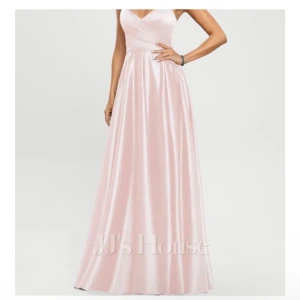 Ljusrosa långklänning med snörning - Säljer en elegant ljusrosa långklänning  i glansigt satinmaterial. Klänningen har v-ringad omlottliv, smala axelband och öppen rygg med snygg snörning. Passformen är normal och kjolen faller mjukt och svepande. Nyköpt 4500kr, kan diskutera priset!💕