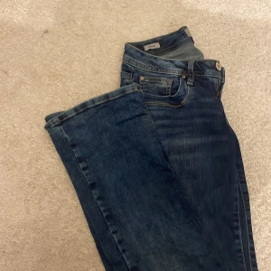 LTB Valerie bootcut jeans blå - Snygga blå jeans från LTB, modell Valerie med bootcut och låg midja. Jeansen har klassisk femficksdesign, kontrastsömmar och en tvättad finish som ger en cool look. Perfekta för dig som gillar en avslappnad men trendig stil.