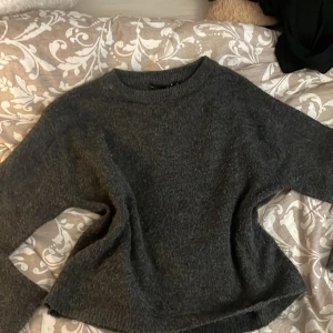 Mörkgrå stickad tröja från 157 - Mysig mörkgrå stickad tröja från 157 i storlek XS. Tröjan har en enkel och avslappnad passform med rund halsringning och långa ärmar vilket gör den till den mysigaste tröjan under hösten och vintern. Perfekt för lager-på-lager under kyliga dagar. Använd några gånger men i bra skick. 🌼