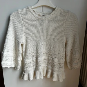 Vit stickad tröja med volang från H&M - Superfin vit stickad tröja från H&M med volangkant nertill och på ärmarna. Skriv gärna ifall ni hade velat se fler bilder av tröjan🥰 Den köptes för 300 kronor och är aldrig använd🫶