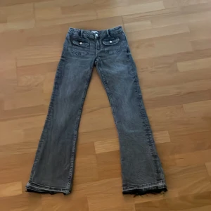 Grå bootcut jeans med råa kanter - Jättefina botcut jeans från Gina Young med snygga fickor på framsidan som är en snygg detalj. Jag har sprättat upp de längst ner så att de passar mig som är 160 vom perfekt. De är i storlek 158 men skulle säga att de är typ xs