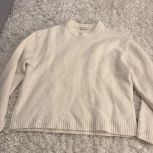 Beige stickad tröja från Gina Tricot - Mysig beige stickad tröja från Gina Tricot i storlek XS. Tröjan har rund hals, ribbade muddar vid ärmslut och nederkant samt långärmad passform. Perfekt för att hålla sig varm under kyliga dagar och har en enkel, clean look.