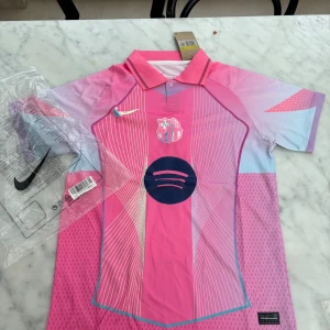 Barça x Nike rosa fotbollströja S - Säljer en Barcelona fotbollströja från Nike i storlek S. Tröjan har en snygg rosa bas med ljusblå och lila detaljer, vita linjer och klubbmärke på bröstet. Klassisk krage och korta ärmar. Materialet är lätt och andas, perfekt för träning eller match.