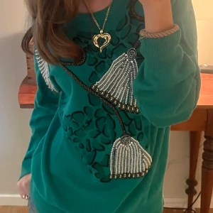 Grön stickad tröja Deluxe Fashion - Grön stickad tröja från Deluxe Fashion med unika pärlbroderier och svarta mönsterdetaljer framtill och baktill. Super cool och snygg tröja för bra pris!