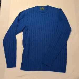 Kabelstickad tröja Alan Paine - Kabelstickad blå tröja från Alan Paine i lyxig bomulls- och kashmirblandning. Aldrig använd. Köpt på Nisses Herrmode i Malmö för 1798kr. Storlek L.