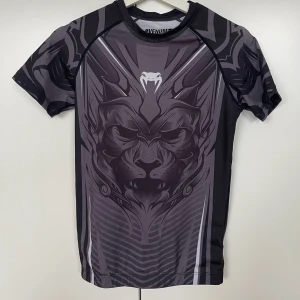 Svart/grå Venum t-shirt - T-shirt från VENUM. Använd och en aning nopprig, därav säljs till en väldigt bra pris. MMA, Boxning/ kampsport tröja 